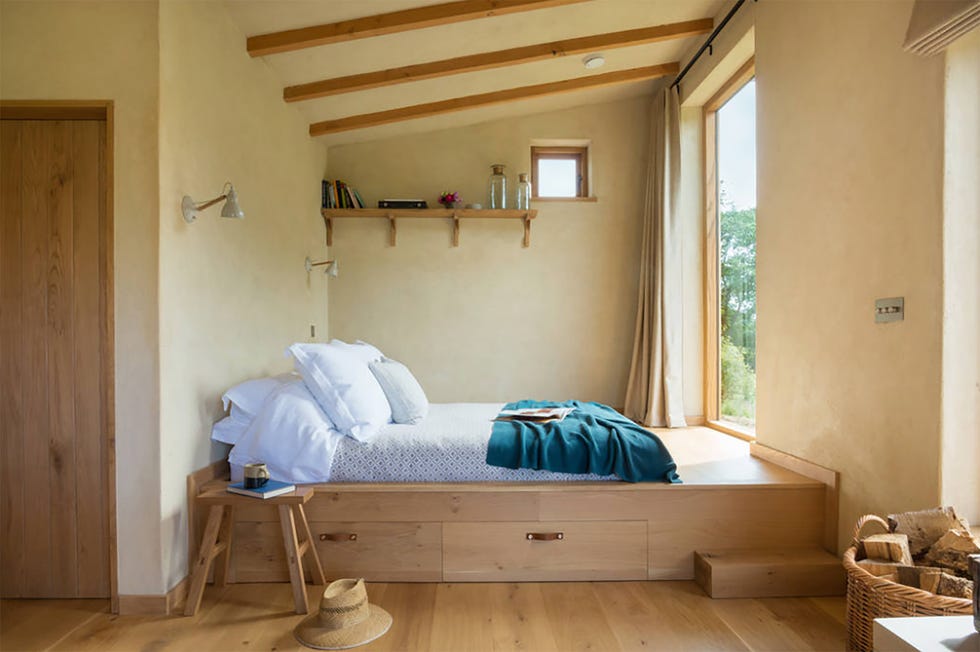 una cabaña de madera sostenible y con un porche para dos personas en medio del campo