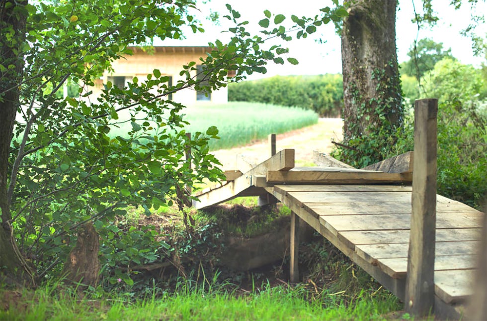 una cabaña de madera sostenible y con un porche para dos personas en medio del campo