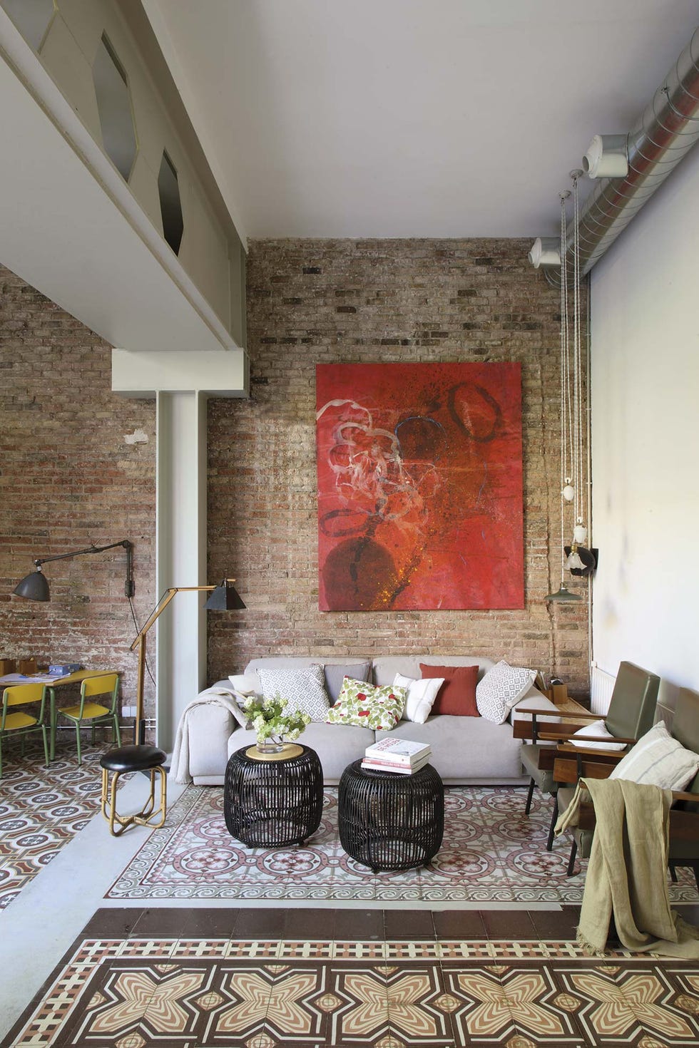 Piso con jardín: Salón con pared de ladrillo