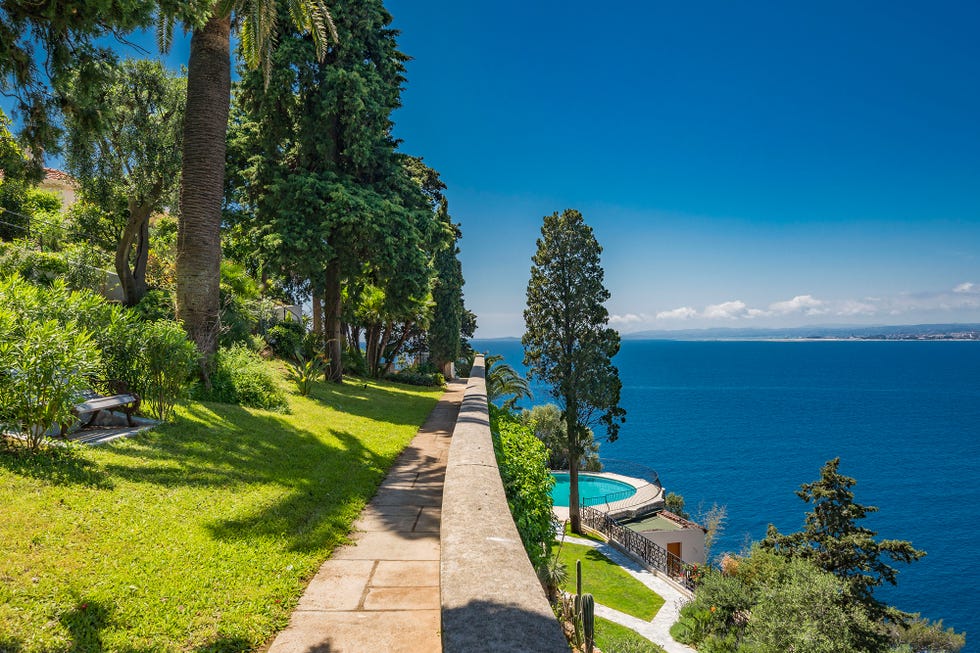 jardín y piscina con vistas al mar