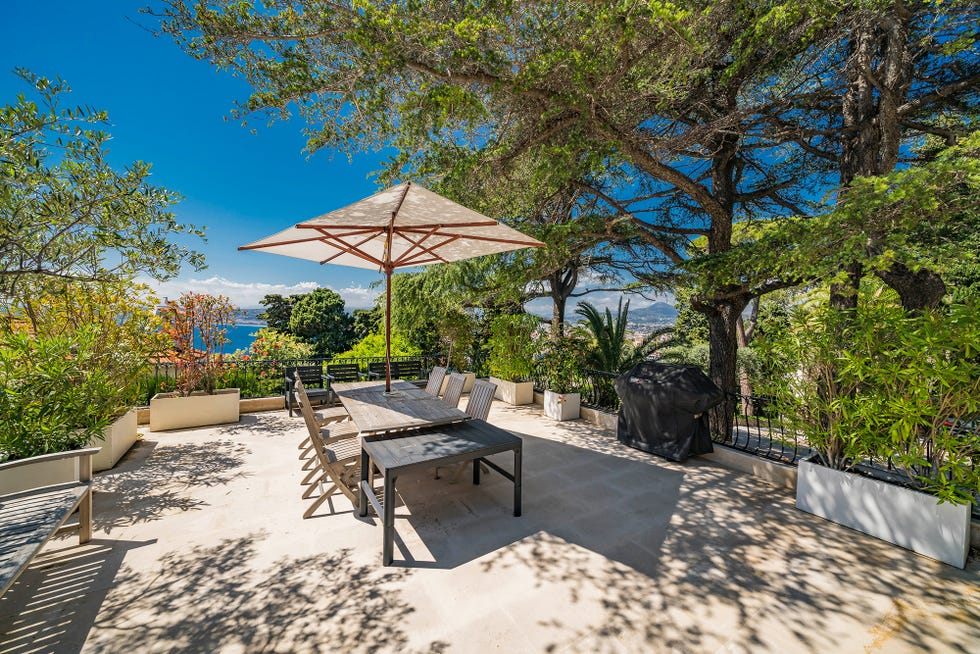 terraza con comedor al aire libre y sombrilla