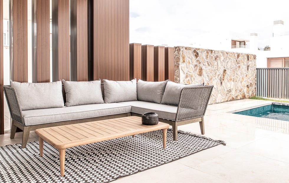terraza con sofá esquinera gris y mesa de centro de madera