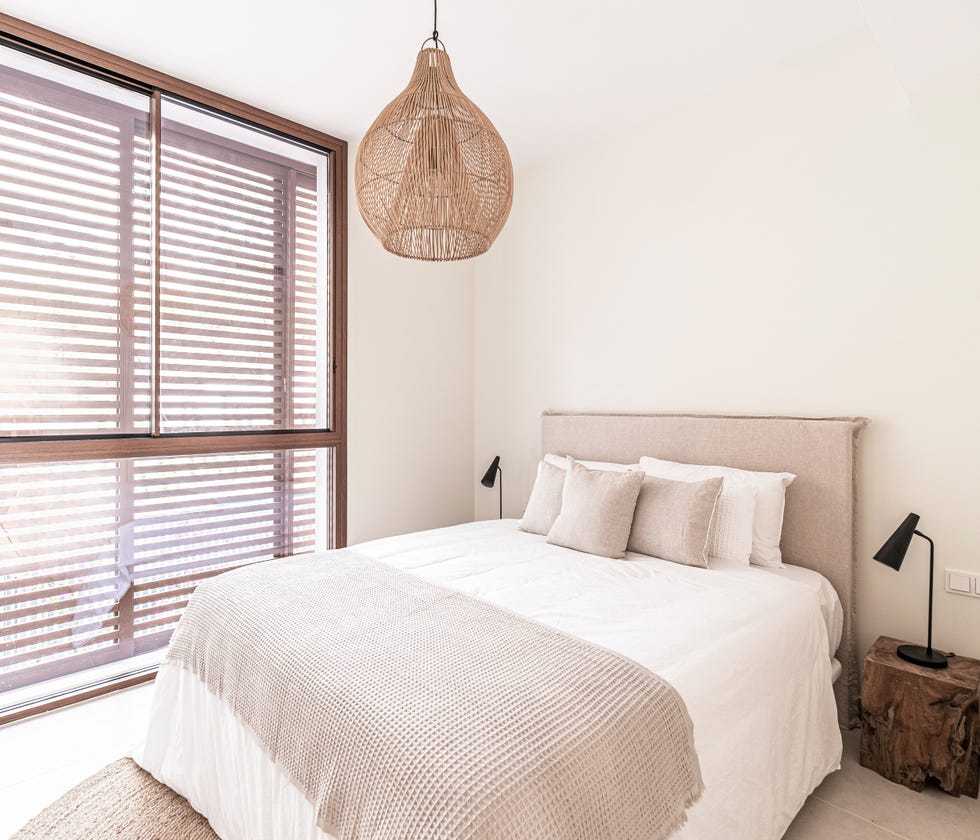 dormitorio decorado en tonos neutros con cabecero tapizado en color gris