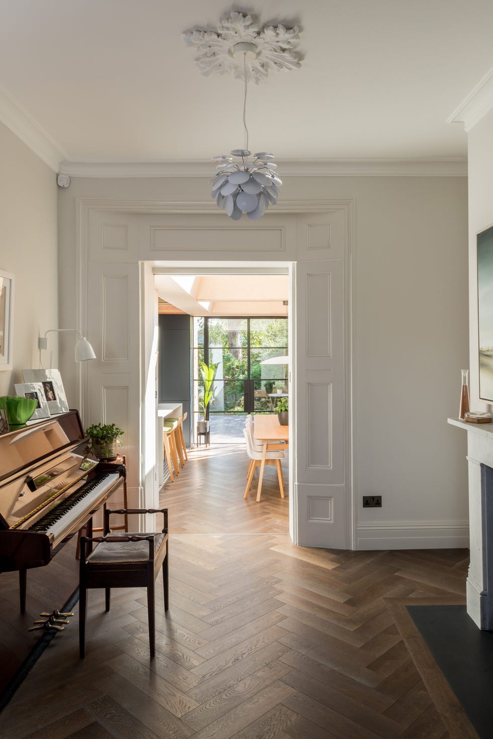 salón con piano y lámpara tipo pétalos