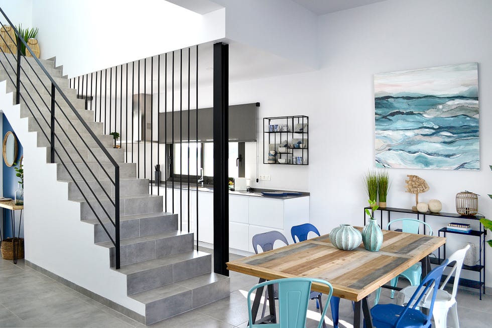 Comedor decorado en tonos azules junto a la escalera