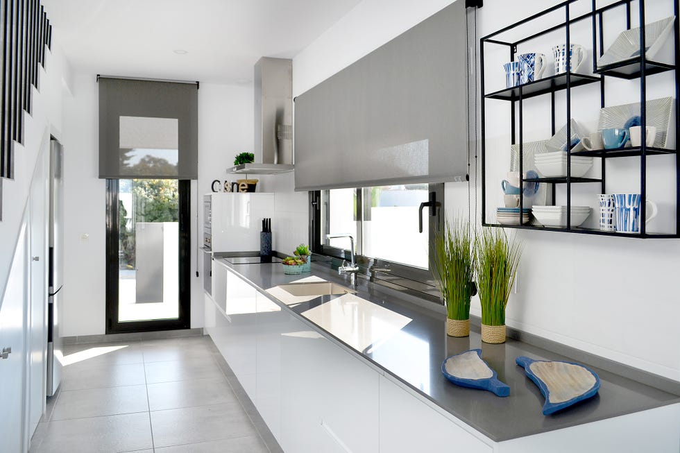 Cocina de color blanco abierta al salón y a la terraza