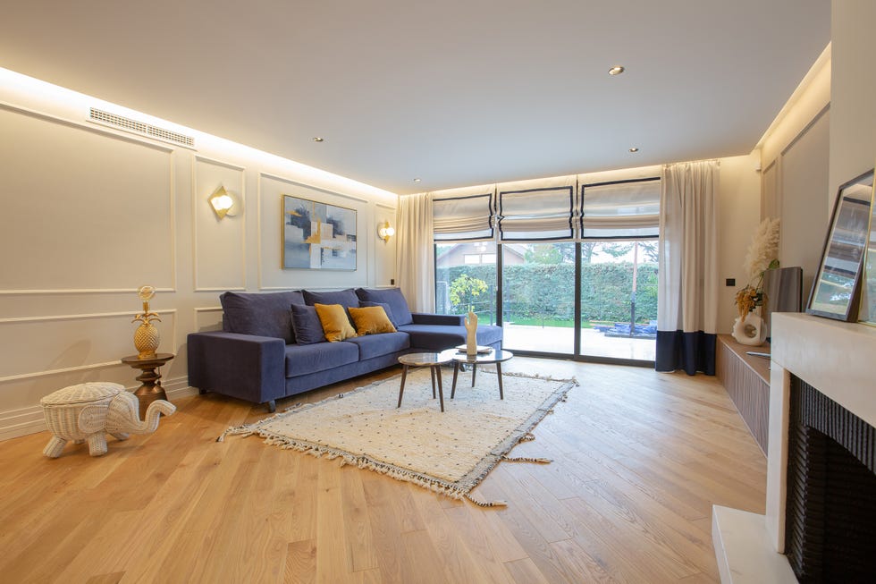 salón decorado con sofá de terciopelo azul con chaise longue y mesas nido