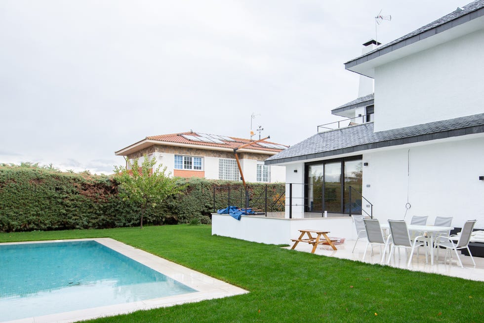 fachada con jardín y piscina