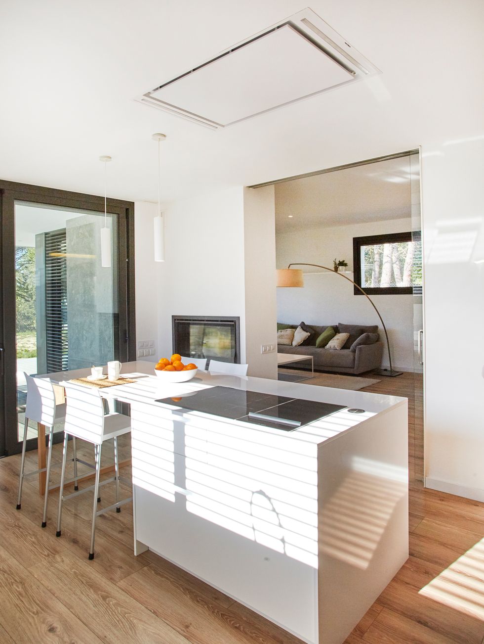 cocina moderna con isla central diseñada en color blanco y puertas sin tiradores