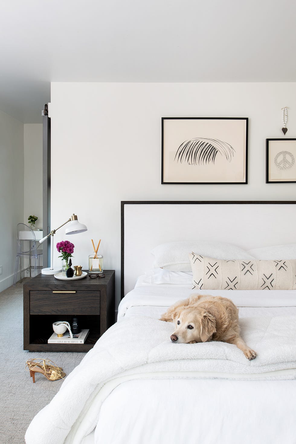 cama con cabecero blanco con marco negro y mesita de noche de madera