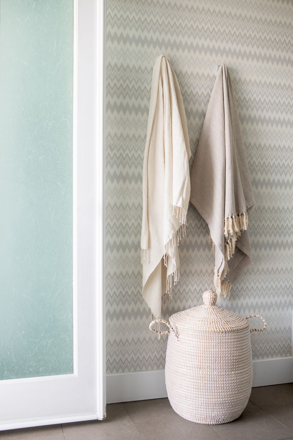 baño con papel pintado en zigzag y cesta de fibras