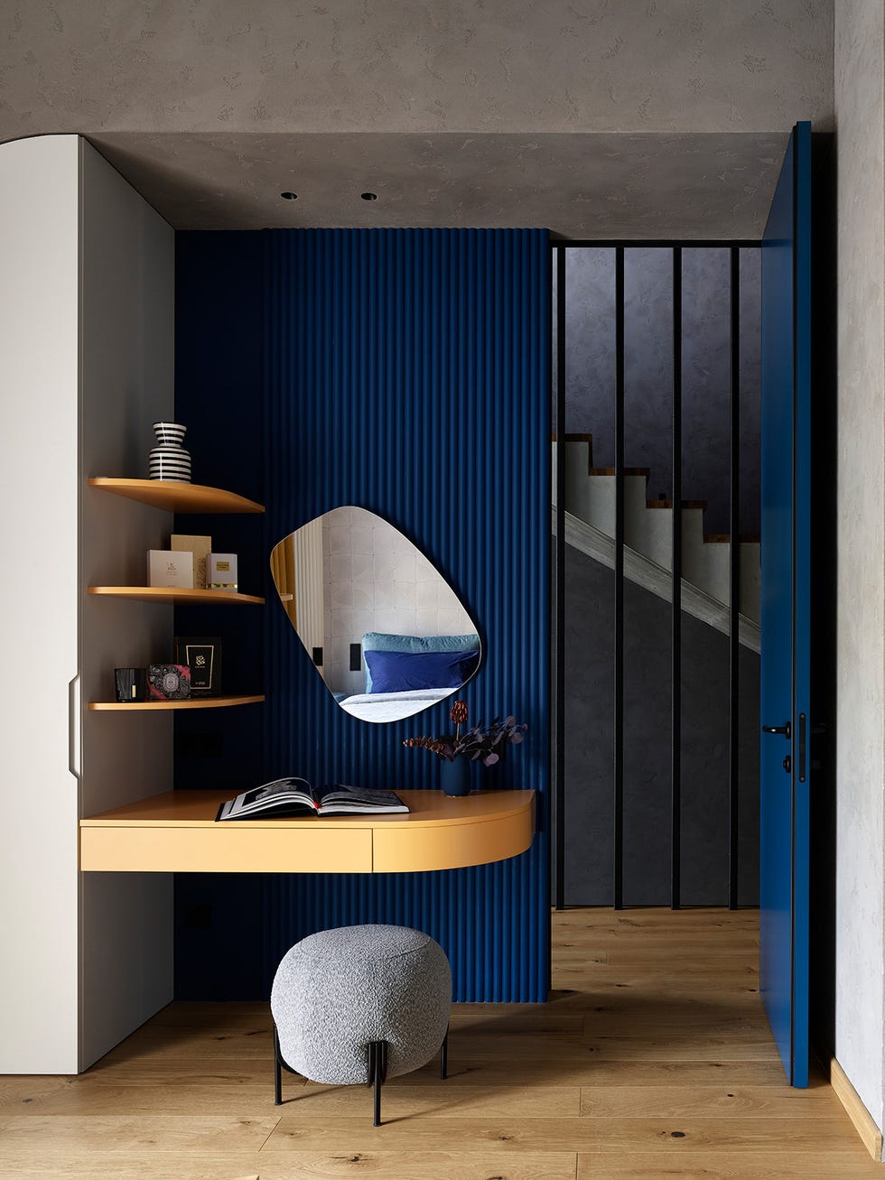escritorio de madera volado y pared acanalada azul