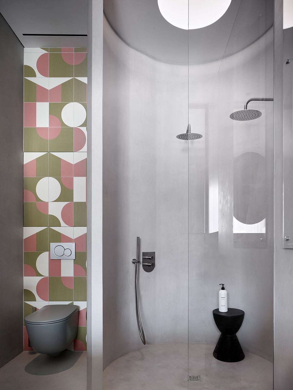 cabina de ducha circular y pared con azulejos geométricos