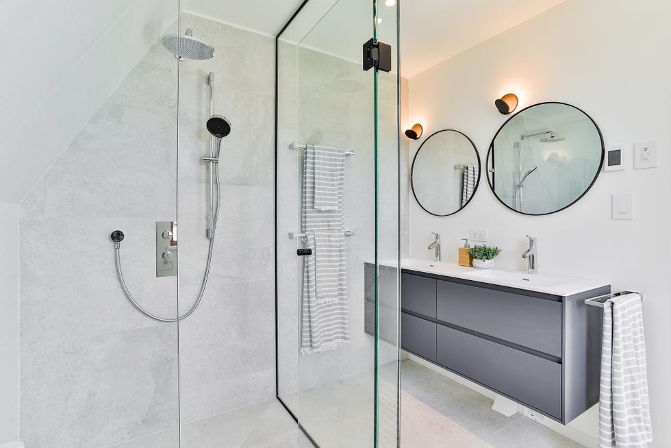 ducha de obra con mueble de lavamanos flotante de diseño moderno y dos espejos redondos