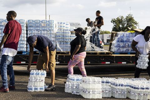 people unpacking pallets of bottled water