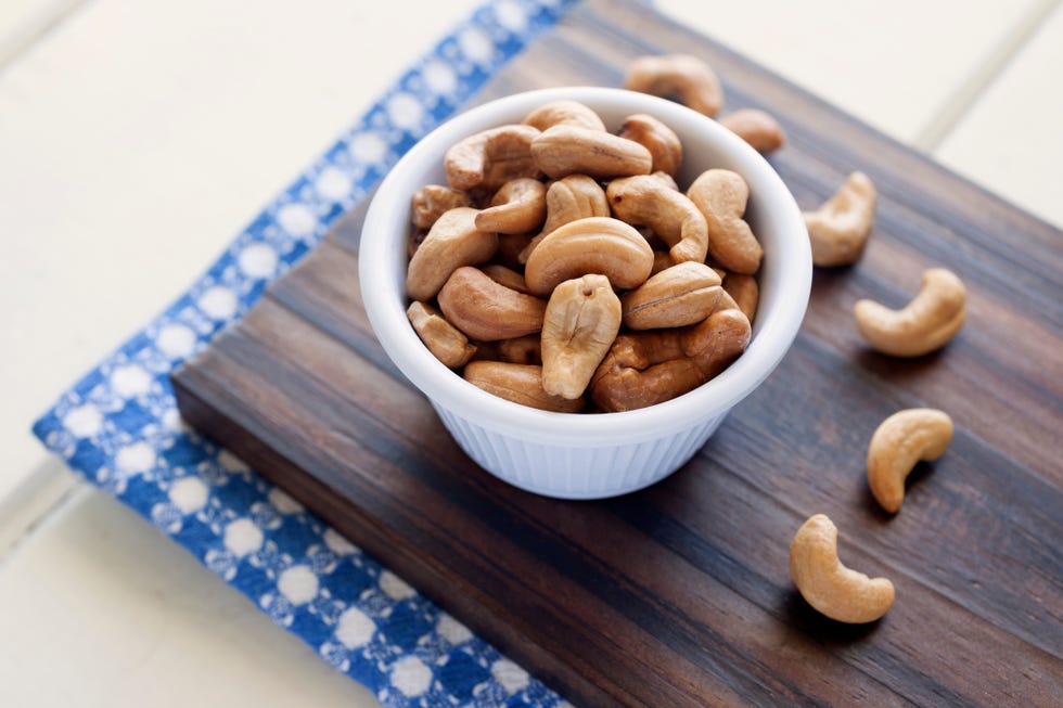 closeup of cashews in bowl on cutting board