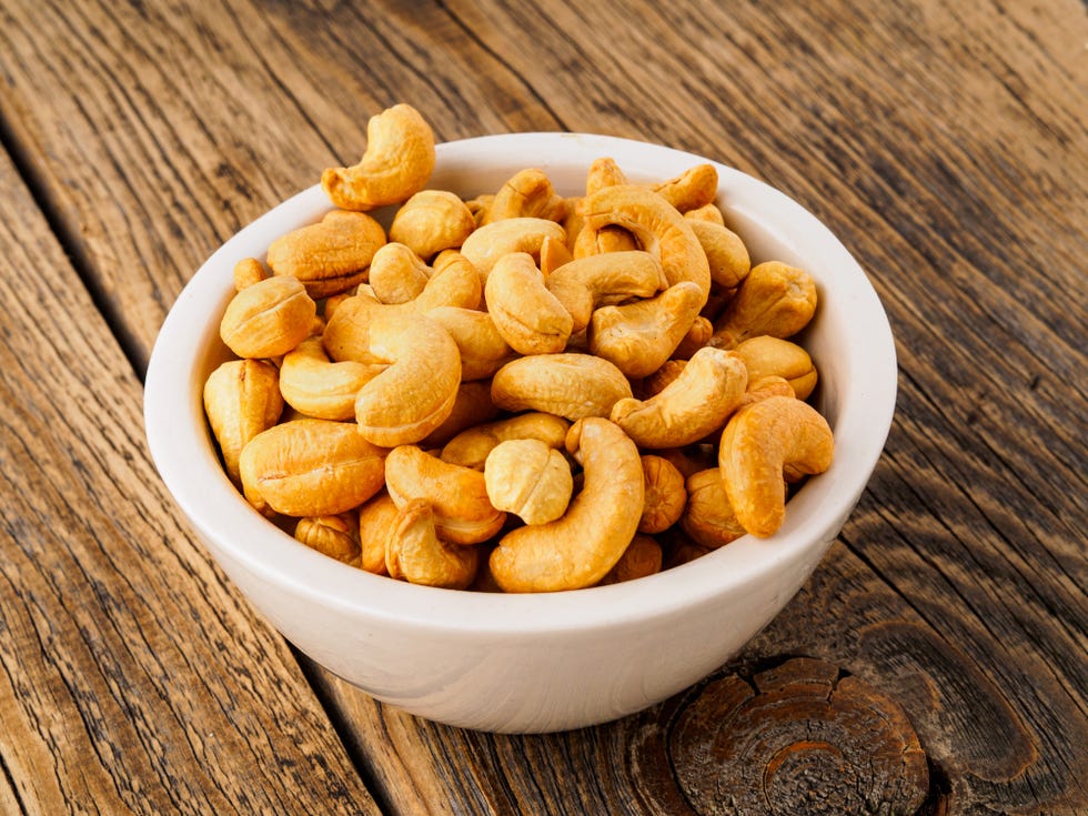 cashew nuts in white bowl on wooden background