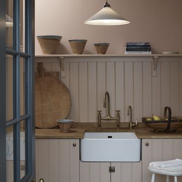 a kitchen with a sink and a shelf with bowls on it