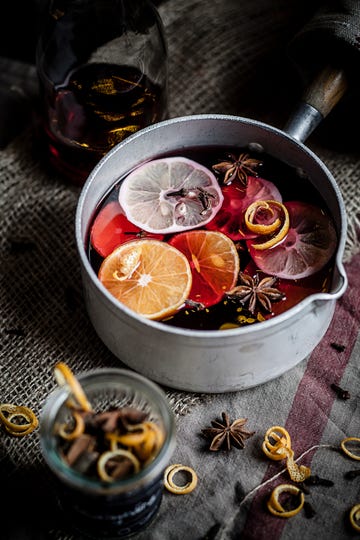 Casserole with mulled wine, slices of lemons and oranges and spices