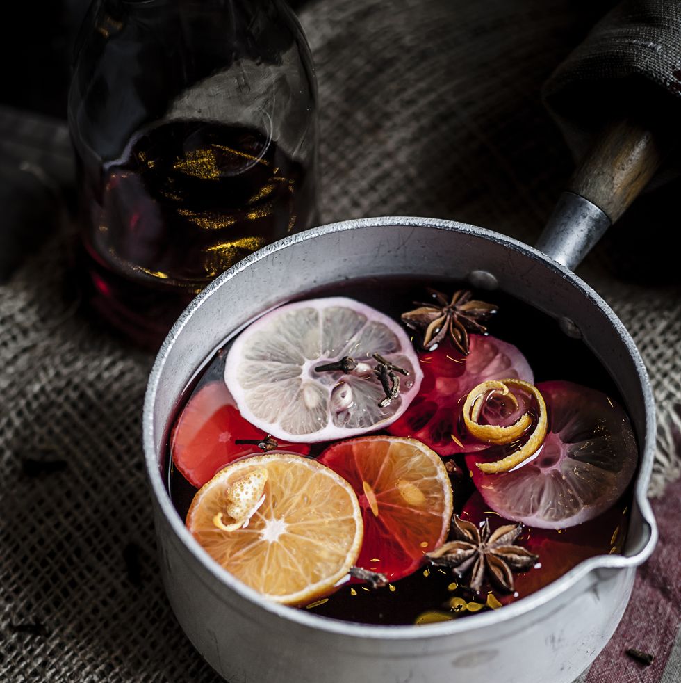Casserole with mulled wine, slices of lemons and oranges and spices