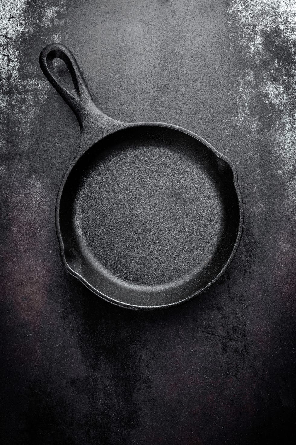cast iron pan on black metal culinary background