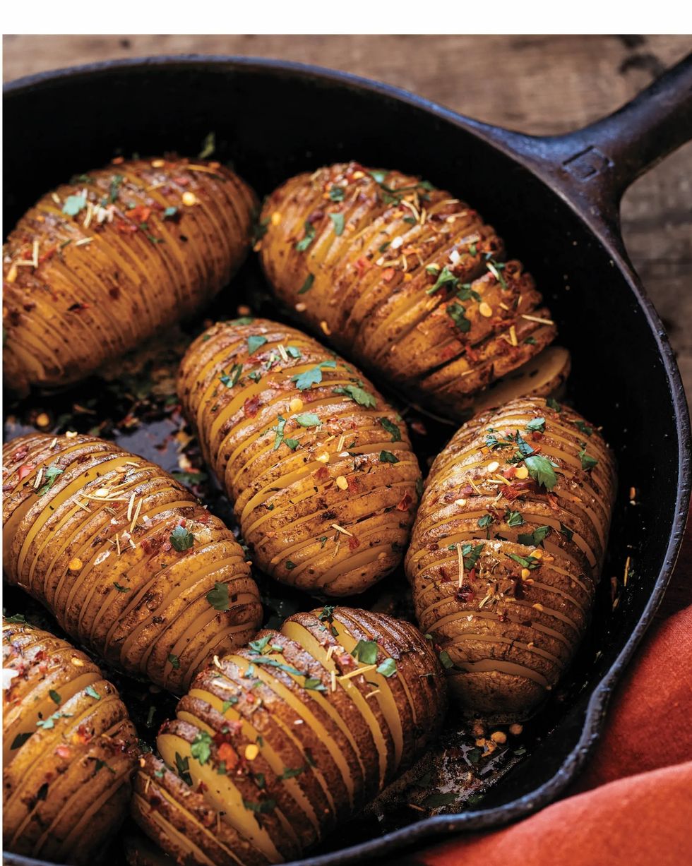 a cast iron pan with hasselback potatoes in it
