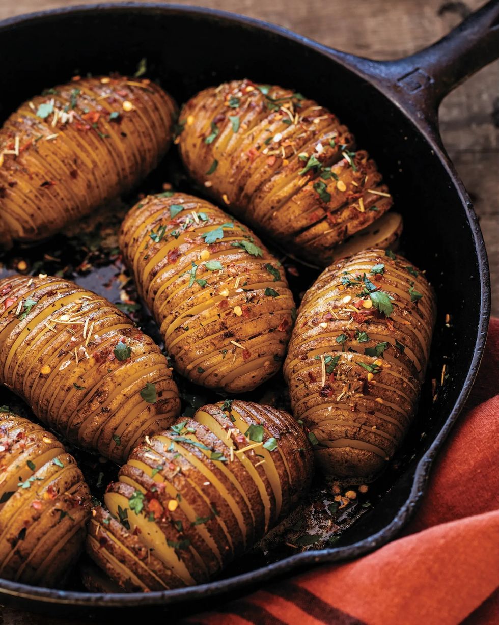 a cast iron pan with hasselback potatoes in it