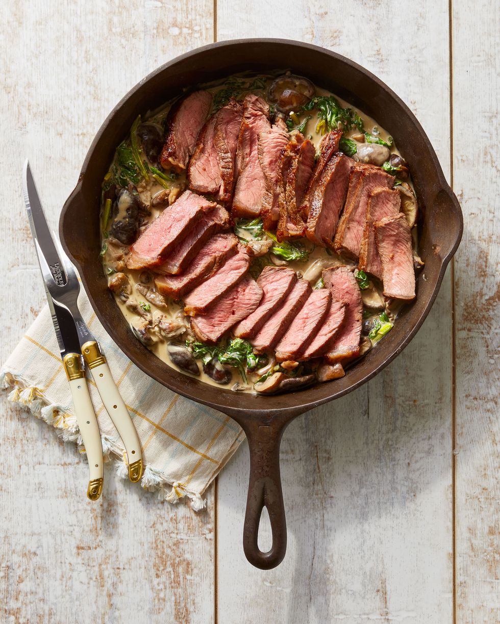 steak with creamy mushrooms and spinach in a cast iron pan