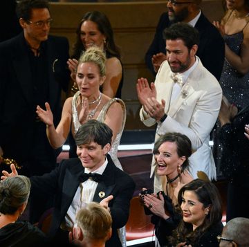 emily blunt, cillian murphy and several other people celebrate while standing and clapping