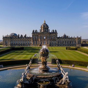 castle howard with a big green lawn in front and a fountain