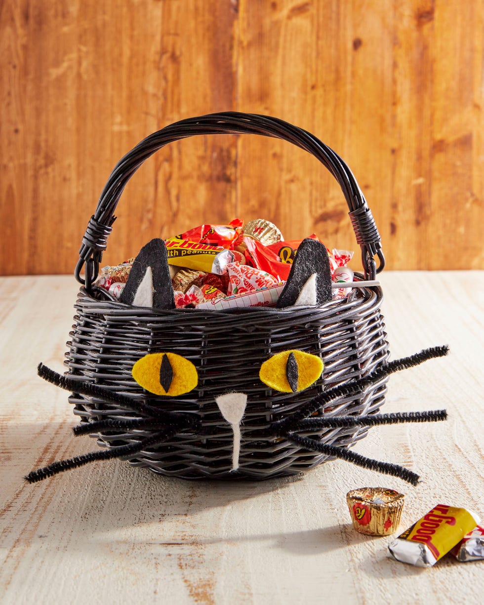 a black basket with a handles and felt pieces added so that it looks like a black cat a black basket with a handles and felt pieces added so that it looks like a black cat