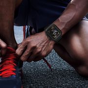 runner tying his shoes with catalyst apple watch case on his wrist