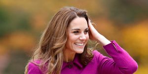 kate middleton in een paarse jas, lachend