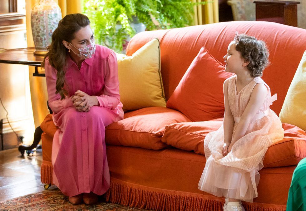 a person sitting on a couch with a person in a pink dress