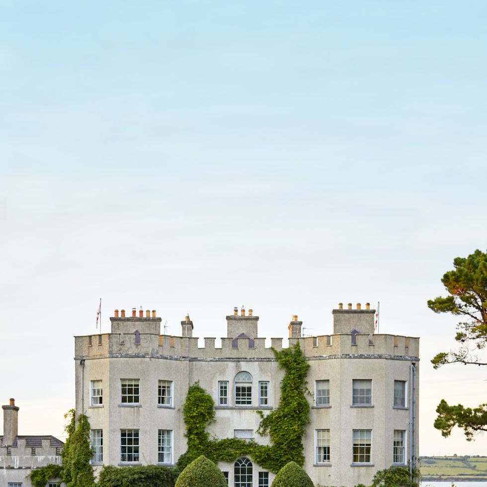 ireland’s glin castle\, owned by landscape designer catherine fitzgerald teardrop shaped yew topiaries welcome guests and culminate in wisteria and a variety of climbing roses scaling the castle walls