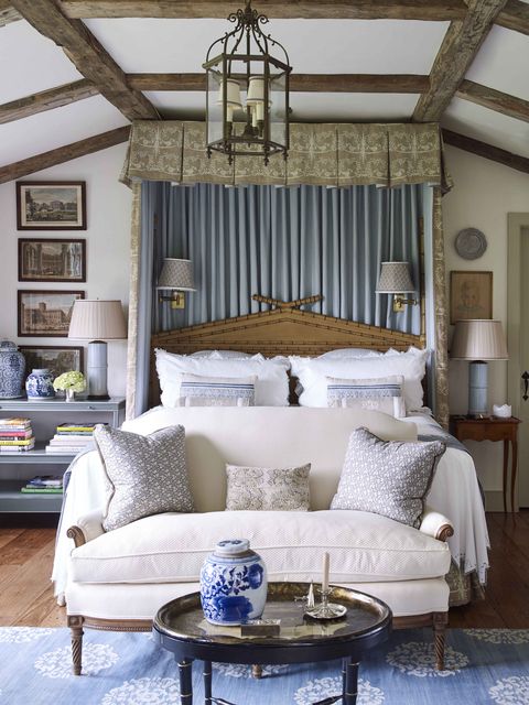the earthy palette in the master bedroom with a taupe bed canopy fabric a sofa and coffee table sit at the base of the bed