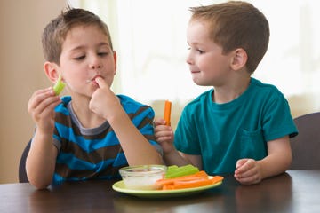 niños merendando dips de verduras