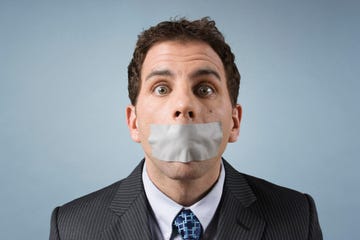 caucasian business man with tape over mouth