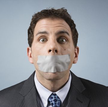 caucasian business man with tape over mouth