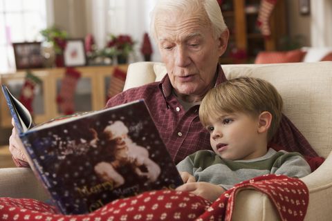 caucasian grandfather reading book to grandson