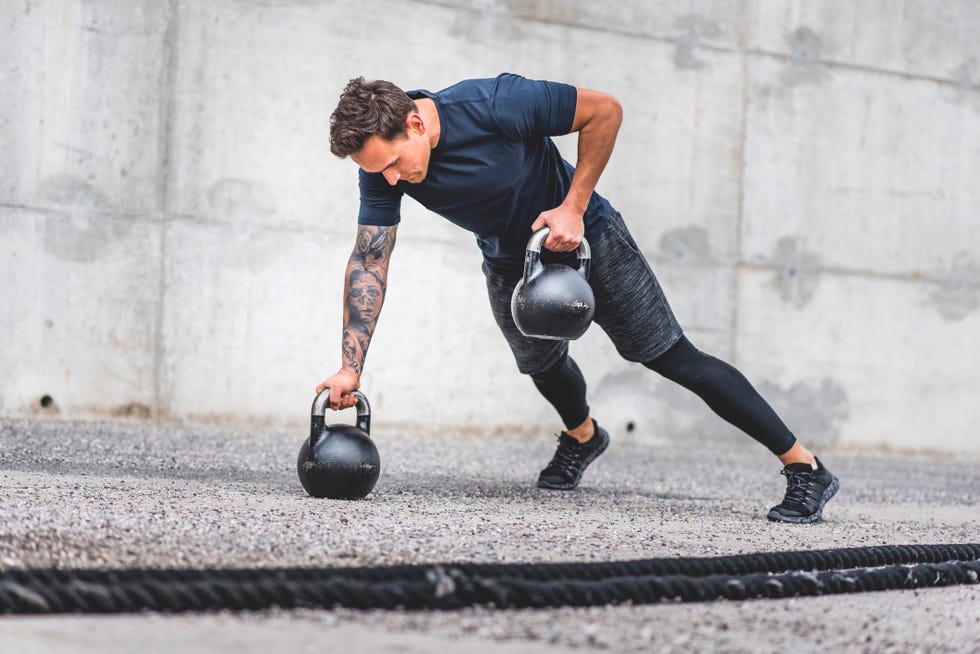 caucasian male athlete doing kettlebell plank row exercise