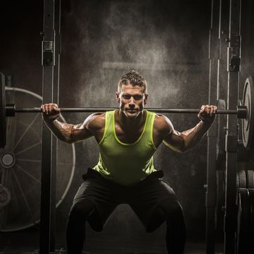 Caucasian man lifting barbell in gymnasium