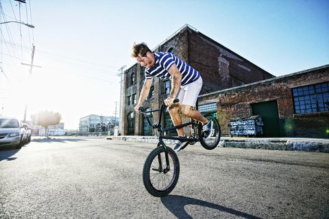 man riding bmx bike on street