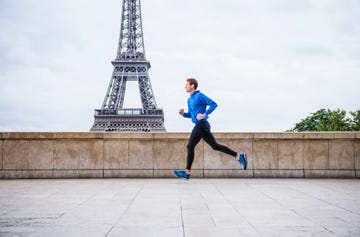 caucasian man running near eiffel tower, paris, france