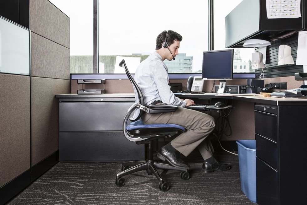 Caucasian man working in an office cubicle.