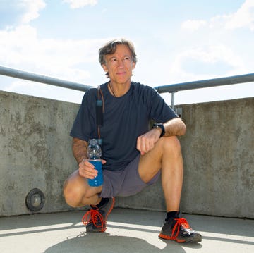 caucasian runner resting on urban rooftop