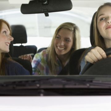 Caucasian teenage girls riding in car