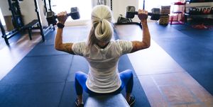 woman lifting dumbbells in gymnasium