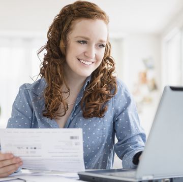 Caucasian woman paying bills using laptop