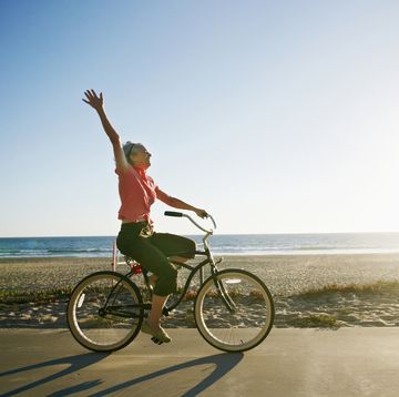 caucasian woman riding bicycle near beach, vitamin d